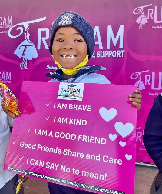 A smiling learner holding the “I am brave, I am kind” anti-bullying pledge